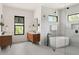 Modern bathroom featuring a soaking tub, dual vanities, and ample natural light from the window at 1624 Turnbull Crossings Dr, New Smyrna Beach, FL 32168