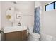 Bathroom featuring a wood vanity, round mirror and shower/tub combo with blue accent curtain at 1624 Turnbull Crossings Dr, New Smyrna Beach, FL 32168