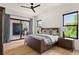 Relaxing bedroom with natural light, wood floors, and seamless access to an outdoor patio at 1624 Turnbull Crossings Dr, New Smyrna Beach, FL 32168