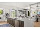 Kitchen island with dishwasher and sink offers seamless flow to dining area with contemporary chandelier lighting at 1624 Turnbull Crossings Dr, New Smyrna Beach, FL 32168