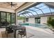 Covered outdoor dining area with a view of the pool and lush landscaping at 1624 Turnbull Crossings Dr, New Smyrna Beach, FL 32168
