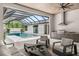 Spacious outdoor living area with a built-in kitchen and seating by a sparkling pool at 1624 Turnbull Crossings Dr, New Smyrna Beach, FL 32168
