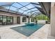 Sparkling pool with a screened enclosure and a water feature, surrounded by a travertine tile patio at 1624 Turnbull Crossings Dr, New Smyrna Beach, FL 32168