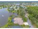 Aerial view of a home with a screened pool, lake view, lush landscaping and trees at 1734 Covendale Ln, Port Orange, FL 32128