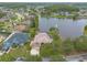 Aerial view of home with a screened in pool, lake, and mature trees at 1734 Covendale Ln, Port Orange, FL 32128