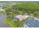 Aerial view of home with a screen enclosed pool, lush landscaping, and lake front view at 1734 Covendale Ln, Port Orange, FL 32128