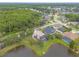 Aerial view of home with lake view, mature trees, screened pool, and landscaped yard at 1734 Covendale Ln, Port Orange, FL 32128