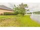 Picturesque backyard featuring lush green lawn, a tranquil lake with fountain and trees, ideal for outdoor enjoyment at 1734 Covendale Ln, Port Orange, FL 32128