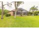 The backyard has lush green grass, mature trees and a screen enclosed pool at 1734 Covendale Ln, Port Orange, FL 32128