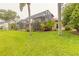 Expansive backyard with tropical landscaping surrounding the screened-in patio and home at 1734 Covendale Ln, Port Orange, FL 32128