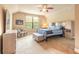 Cozy bedroom with neutral walls, ceiling fan, carpet flooring, and furnishings including a chair and striped bedding at 1734 Covendale Ln, Port Orange, FL 32128