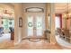 Inviting foyer with tile flooring, decorative glass doors, transom window, and views into the dining and living areas at 1734 Covendale Ln, Port Orange, FL 32128