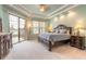 A gorgeous main bedroom features a tray ceiling, outside access to a seating area, and two dressers at 1734 Covendale Ln, Port Orange, FL 32128