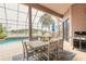 Enclosed patio featuring a dining area, grill, and swimming pool overlooking tranquil lake at 1734 Covendale Ln, Port Orange, FL 32128