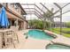 Beautiful screened-in pool area with lush landscaping, patio furniture, and a relaxing spa at 1734 Covendale Ln, Port Orange, FL 32128