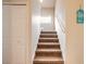 Carpeted staircase leading upstairs with white walls, doors, and railing, bright and airy at 1734 Covendale Ln, Port Orange, FL 32128