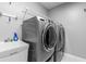 Well-organized laundry room with washer, dryer, utility sink, and ample shelving at 1845 Willow Oak Dr, Edgewater, FL 32141