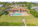 Aerial view of a home's backyard features a pool, patio, and mature landscaping at 1905 S Riverside Dr, Edgewater, FL 32141