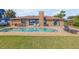 Home's backyard pool is surrounded by a brick patio and lush lawn at 1905 S Riverside Dr, Edgewater, FL 32141