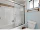A bathtub with a shower featuring clear glass doors in a neutral bathroom at 1905 S Riverside Dr, Edgewater, FL 32141