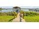 A wooden walkway leads to a covered boat dock, surrounded by lush greenery on a sunny day at 1905 S Riverside Dr, Edgewater, FL 32141