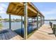 A covered boat lift featuring a wood dock with a waterfront view, and a well-maintained structure at 1905 S Riverside Dr, Edgewater, FL 32141