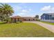Charming brick home featuring a spacious front yard, mature palm trees and an extended driveway at 1905 S Riverside Dr, Edgewater, FL 32141