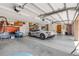 Well-lit garage featuring a gray Corvette, ample storage solutions, and recreational equipment storage on the walls at 1905 S Riverside Dr, Edgewater, FL 32141