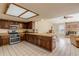 Bright kitchen boasts wood cabinets, stainless appliances, and an open layout with brick fireplace views at 1905 S Riverside Dr, Edgewater, FL 32141