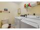 Functional laundry room with a washing machine, dryer, toilet, and storage shelf at 1905 S Riverside Dr, Edgewater, FL 32141