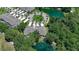 Detailed aerial view of a home with a circular driveway surrounded by trees and a pond at 1999 Turnbull Lakes Dr, New Smyrna Beach, FL 32168