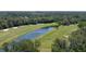 Beautiful aerial view of the golf course and pond surrounded by lush green trees at 1999 Turnbull Lakes Dr, New Smyrna Beach, FL 32168