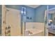 Relaxing bathroom with tub and shower combination next to the bedroom, decorated with beach decor at 1999 Turnbull Lakes Dr, New Smyrna Beach, FL 32168