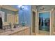 Bathroom featuring double sinks, granite countertops, and a walk-in shower at 1999 Turnbull Lakes Dr, New Smyrna Beach, FL 32168