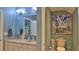 Bright bathroom featuring double sinks, granite countertop, and a decorative ocean themed art print at 1999 Turnbull Lakes Dr, New Smyrna Beach, FL 32168