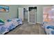 Bright bedroom featuring twin beds, closet and storage, carpet, with easy access to stairs at 1999 Turnbull Lakes Dr, New Smyrna Beach, FL 32168