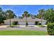 Charming townhome featuring a well-manicured lawn, palm trees, and a two-car garage at 1999 Turnbull Lakes Dr, New Smyrna Beach, FL 32168