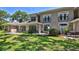 Elegant multi-story home featuring arched windows, small balconies, and a well-manicured lawn at 1999 Turnbull Lakes Dr, New Smyrna Beach, FL 32168