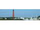 Historic lighthouse rises above a marina with boats; a beacon of nautical charm at 1999 Turnbull Lakes Dr, New Smyrna Beach, FL 32168