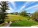 Spacious backyard with lush green grass, manicured landscaping, and a view of the golf course at 2005 Country Club Dr, Port Orange, FL 32128