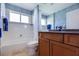 Charming bathroom featuring a tub and shower combo and vanity with striking blue patterned wallpaper at 2005 Country Club Dr, Port Orange, FL 32128