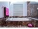 Bright bathtub area with a large window, marble accents, and glass enclosed shower at 2005 Country Club Dr, Port Orange, FL 32128