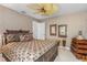 Comfortable bedroom featuring an ornate metal bed frame, ceiling fan, and wooden chest at 2005 Country Club Dr, Port Orange, FL 32128