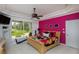 Bright bedroom with a colorful accent wall, sliding glass door to the backyard, and a ceiling fan at 2005 Country Club Dr, Port Orange, FL 32128