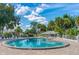 A beautifully maintained community pool sparkles under a blue sky, surrounded by palm trees and comfortable lounge seating at 2005 Country Club Dr, Port Orange, FL 32128