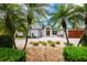 Beautiful two-story home with a paver driveway, complemented by colorful flowers and lush tropical landscaping at 2005 Country Club Dr, Port Orange, FL 32128