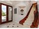 Elegant foyer with grand staircase, wood railing, tile flooring and double door entrance at 2005 Country Club Dr, Port Orange, FL 32128