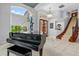 Open foyer with a grand piano, staircase, tile flooring, and plenty of natural light from large windows at 2005 Country Club Dr, Port Orange, FL 32128