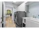 Bright laundry room with washer, dryer, utility sink, and access to the kitchen at 2005 Country Club Dr, Port Orange, FL 32128