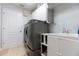 Well-equipped laundry room with a washer, dryer, sink, storage cabinets, and door at 2005 Country Club Dr, Port Orange, FL 32128